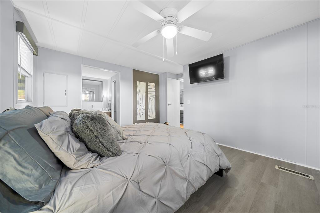 426 Northwest 5th Road Lake Panasoffkee, FL 33538 - Photo 14 of 51 a spacious bedroom with a bed and a flat screen tv