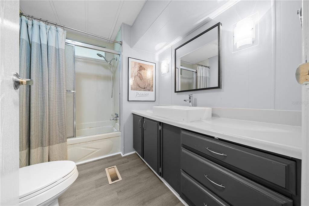 426 Northwest 5th Road Lake Panasoffkee, FL 33538 - Photo 23 of 51 a bathroom with a granite countertop sink a toilet a mirror and shower