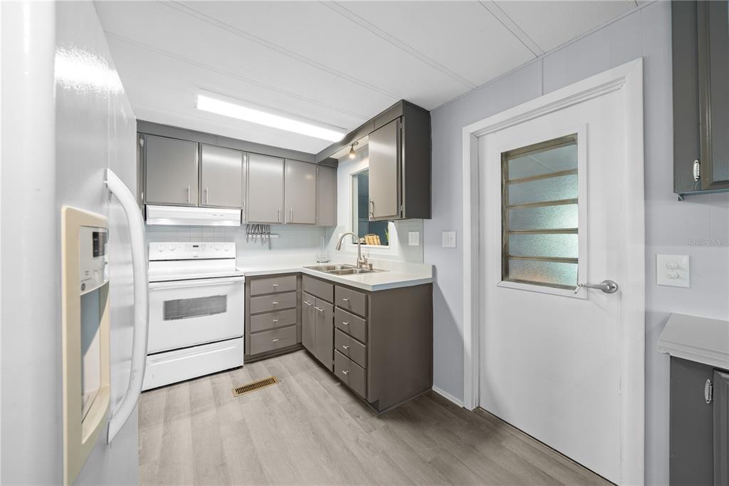 426 Northwest 5th Road Lake Panasoffkee, FL 33538 - Photo 6 of 51 a kitchen with a white stove top oven and sink