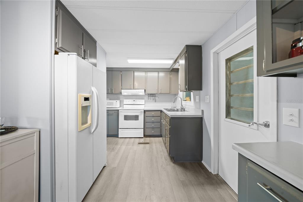 426 Northwest 5th Road Lake Panasoffkee, FL 33538 - Photo 7 of 51 a kitchen with stainless steel appliances a refrigerator sink and cabinets