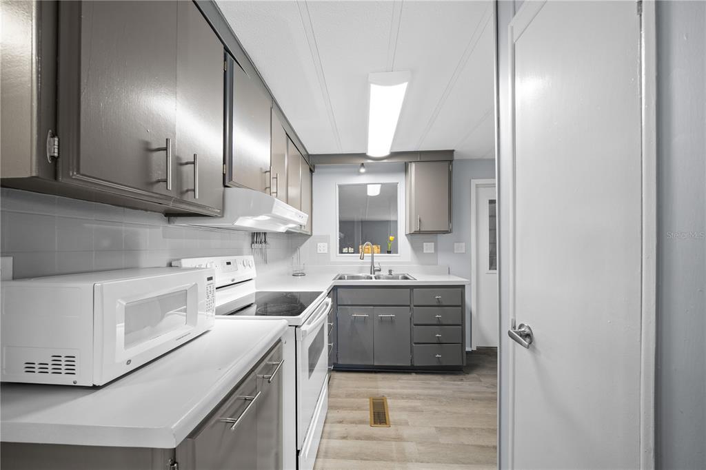 426 Northwest 5th Road Lake Panasoffkee, FL 33538 - Photo 8 of 51 a kitchen with a sink cabinets and stove