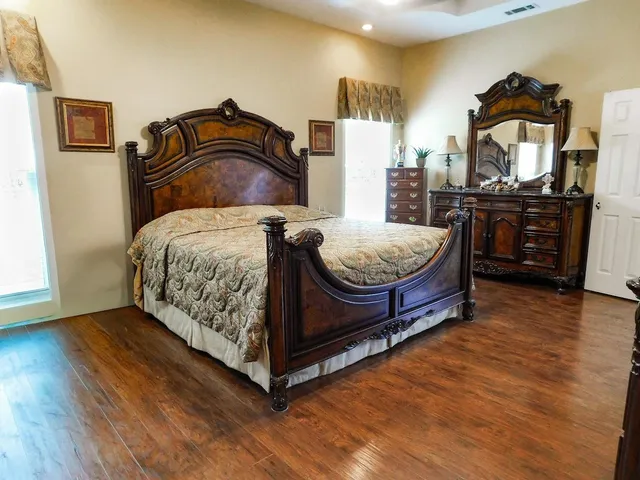 a bedroom with a bed and wooden floor
