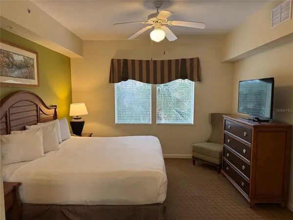 a spacious bedroom with a bed and a chandelier