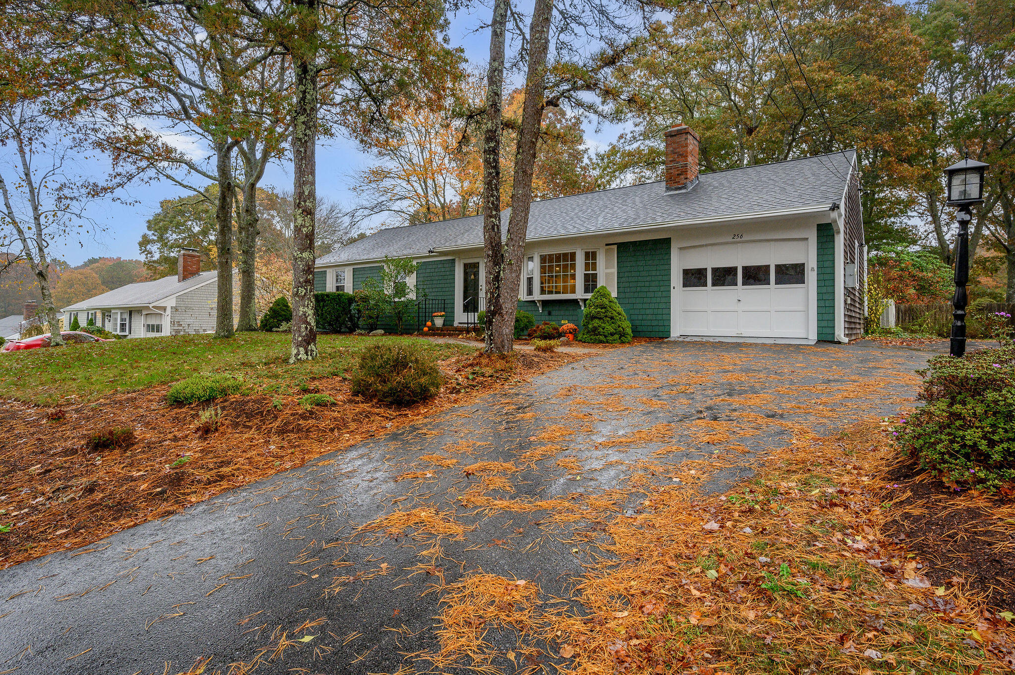256 Buckskin Path Centerville, MA 02632 - Photo 2 of 38 a front view of a house with a garden and trees