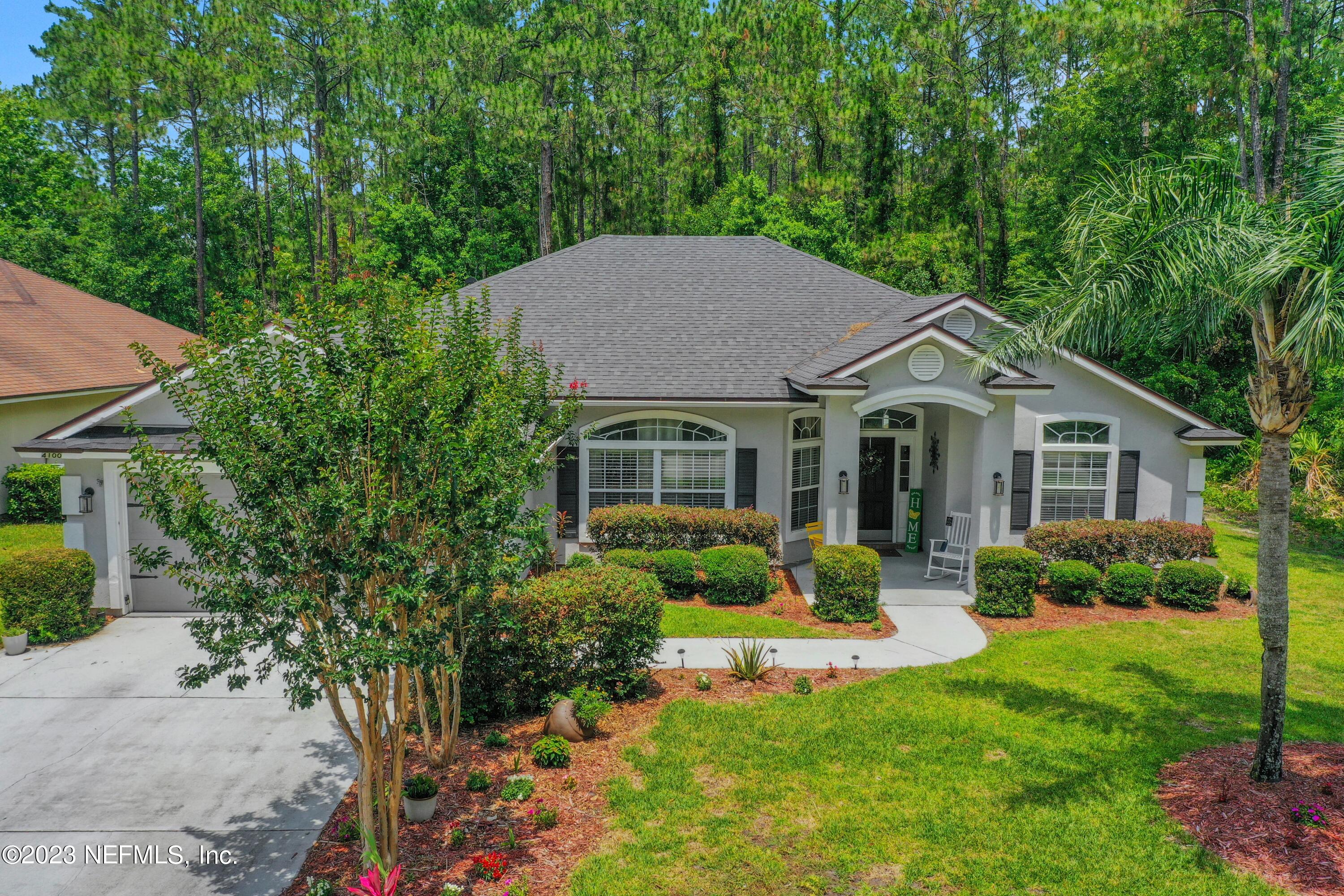 a front view of a house with yard and green space
