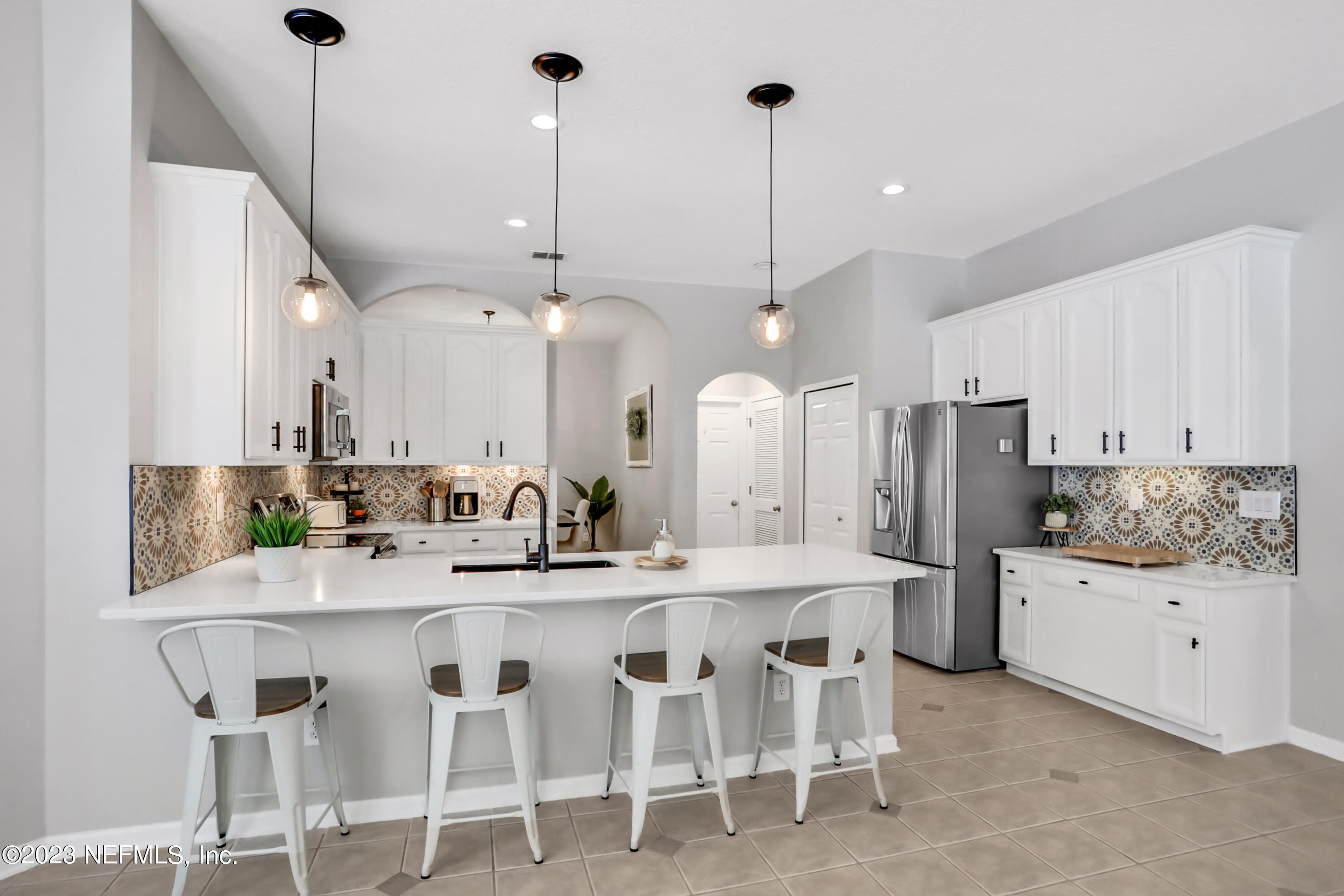 4100 Lonicera Loop St. Johns, FL 32259 - Photo 13 of 65 a kitchen with stainless steel appliances kitchen island granite countertop a table chairs and a sink
