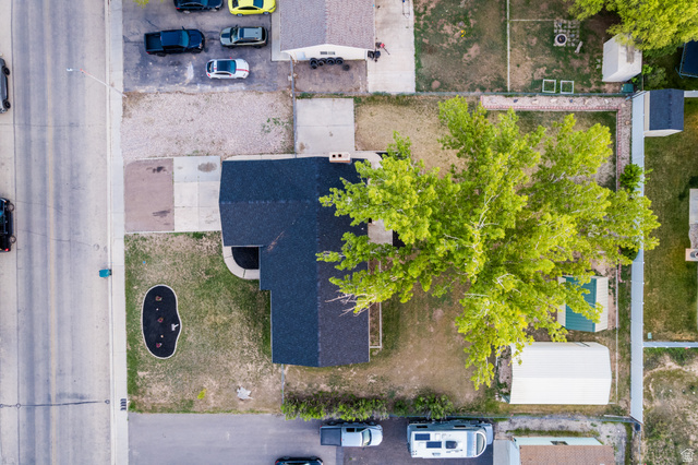 634 South 2100th Street West Vernal, UT 84078 - Photo 64 of 71 Overhead property view featuring a residence with a dark shingle roof, a paved driveway, and a large, mature tree providing ample shade
