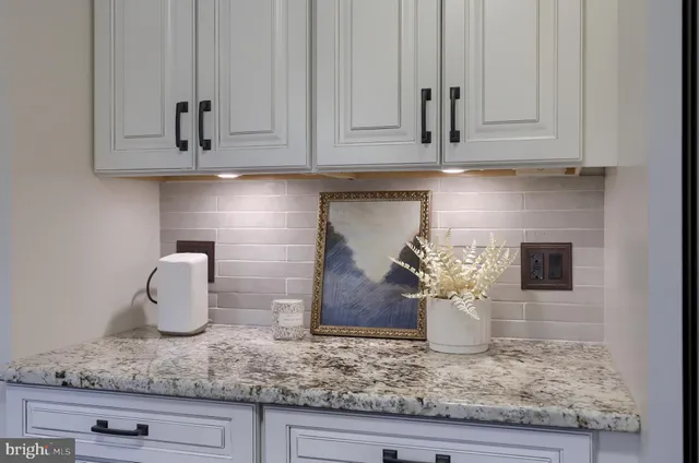 a kitchen with granite countertop white cabinets and a white stainless steel appliances