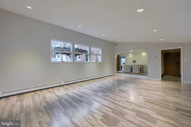 an empty room with wooden floor and a window
