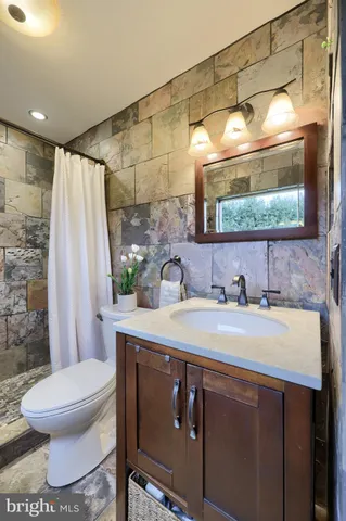 a bathroom with a sink toilet a mirror and shower