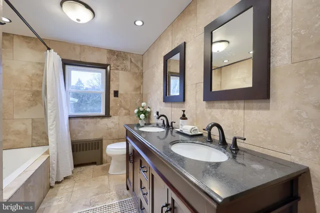 a living room with stainless steel appliances furniture a rug and a view of kitchen