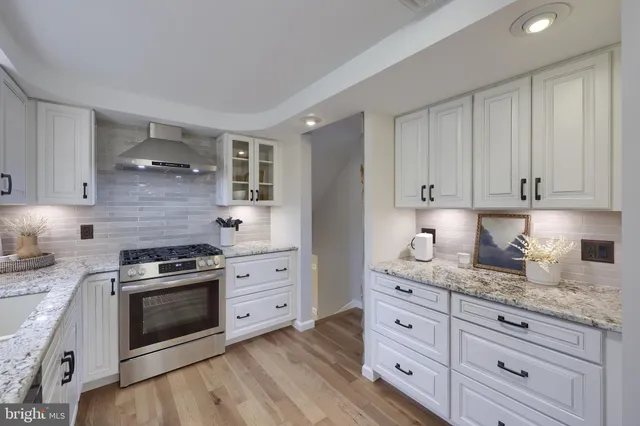 a kitchen with granite countertop white cabinets and stainless steel appliances