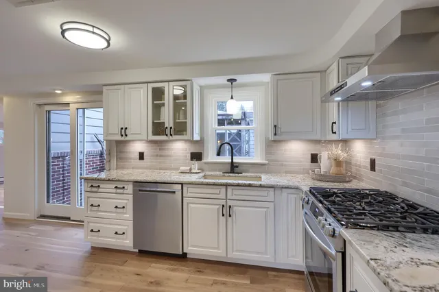 a kitchen with stainless steel appliances a stove sink and cabinets