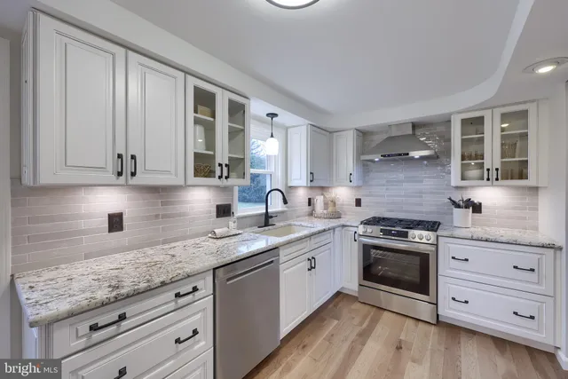 a kitchen with granite countertop a sink stainless steel appliances and cabinets