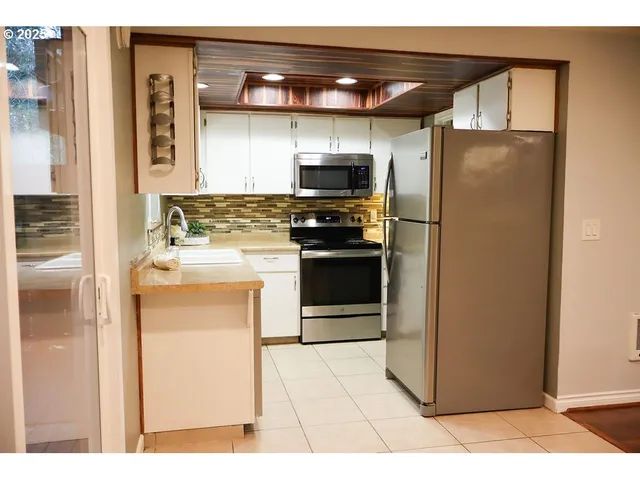 a kitchen with stainless steel appliances granite countertop a refrigerator and a stove