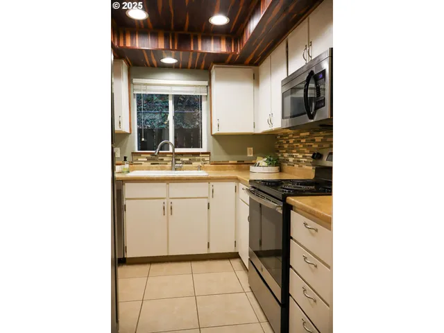 a kitchen with a sink cabinets and a window