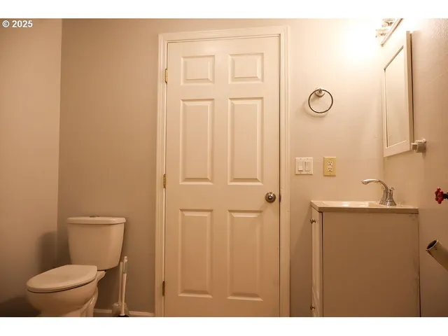 a bathroom with a toilet a sink and mirror
