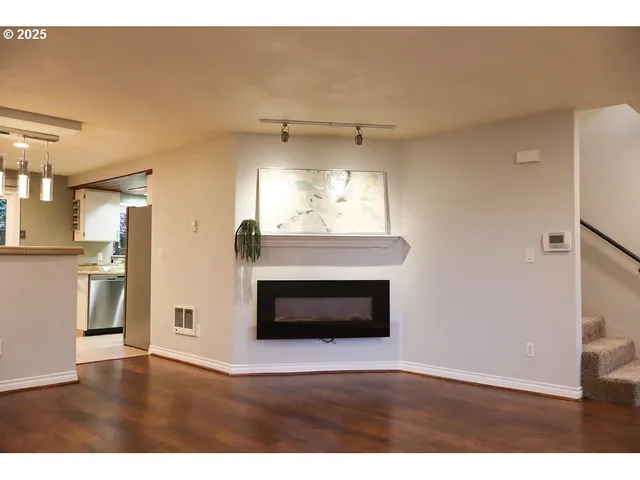 a view of a livingroom with a fireplace and wooden floor
