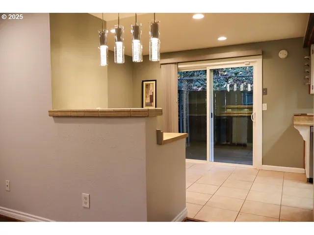 a view of open kitchen with granite countertop cabinets and refrigerator
