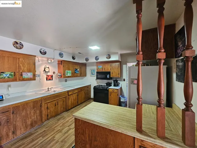 a large kitchen with stainless steel appliances kitchen island granite countertop a refrigerator and a stove top oven