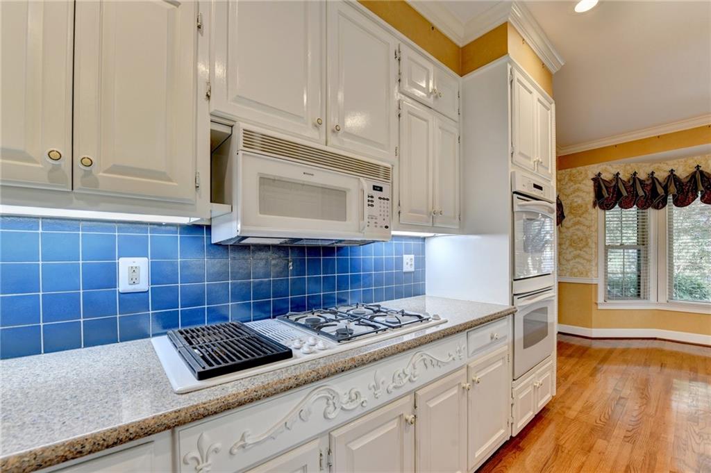 2859 Village Court Gainesville, GA 30506 - Photo 11 of 27 a kitchen with granite countertop a sink a stove and cabinets