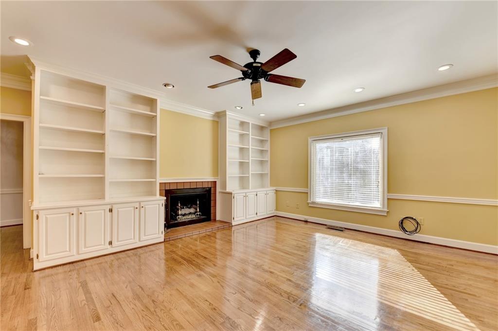 2859 Village Court Gainesville, GA 30506 - Photo 12 of 27 a view of a livingroom with a fireplace a ceiling fan and windows