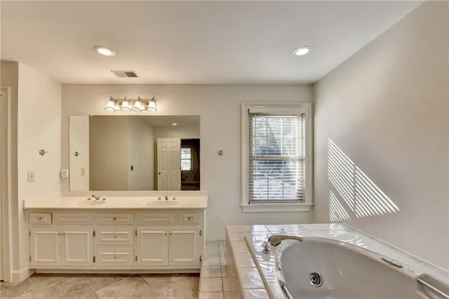 a bathroom with a double vanity sink and a mirror