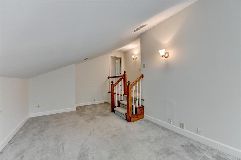 2859 Village Court Gainesville, GA 30506 - Photo 22 of 27 an empty room with a chandelier fan and windows