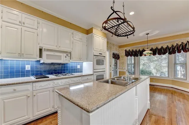 a kitchen with granite countertop a sink a stove and cabinets
