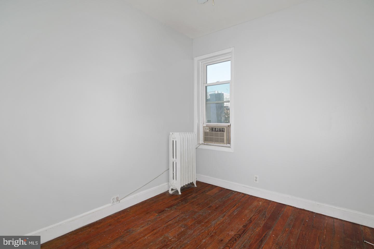 2324 Poplar Street, Unit 2F Philadelphia, PA 19130 - Photo 18 of 24 an empty room with wooden floor and windows