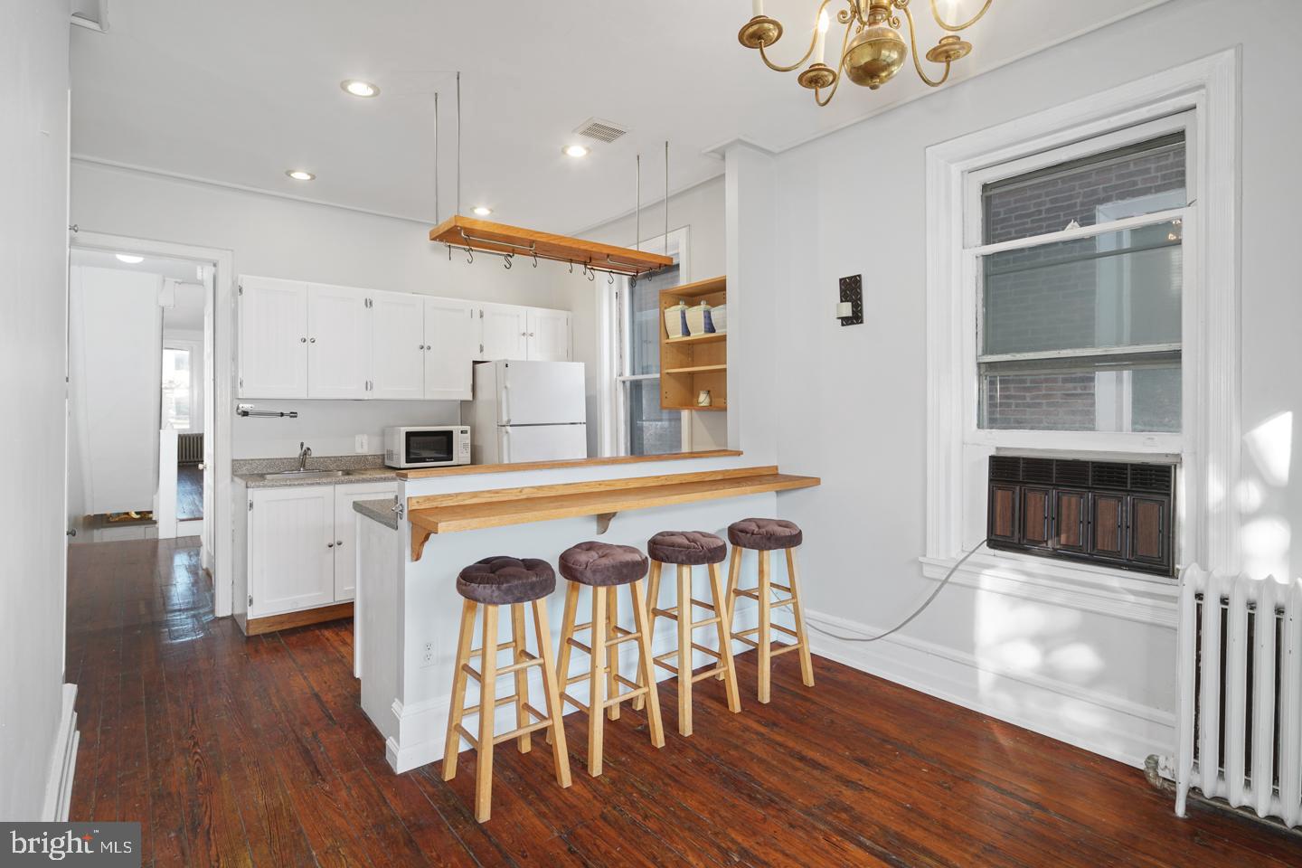 2324 Poplar Street, Unit 2F Philadelphia, PA 19130 - Photo 2 of 24 a kitchen with wooden floors and white cabinets