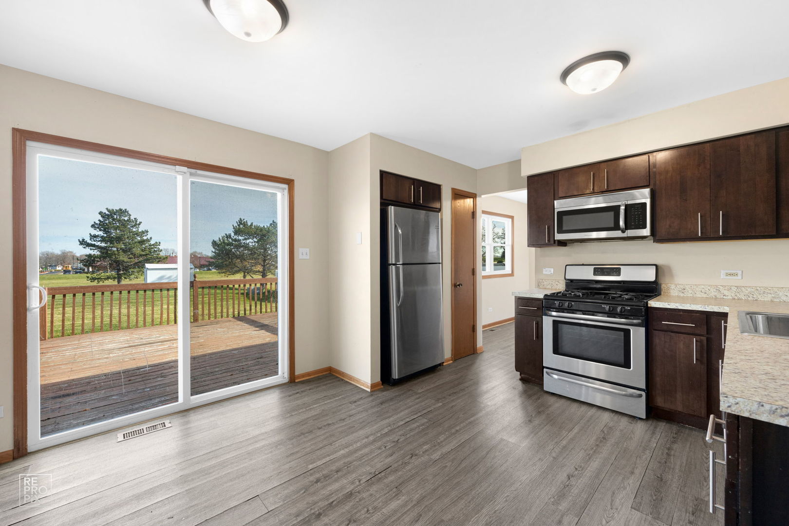 309 Wheatfield Road Matteson, IL 60443 - Photo 10 of 22 a kitchen with granite countertop a refrigerator and a stove top oven