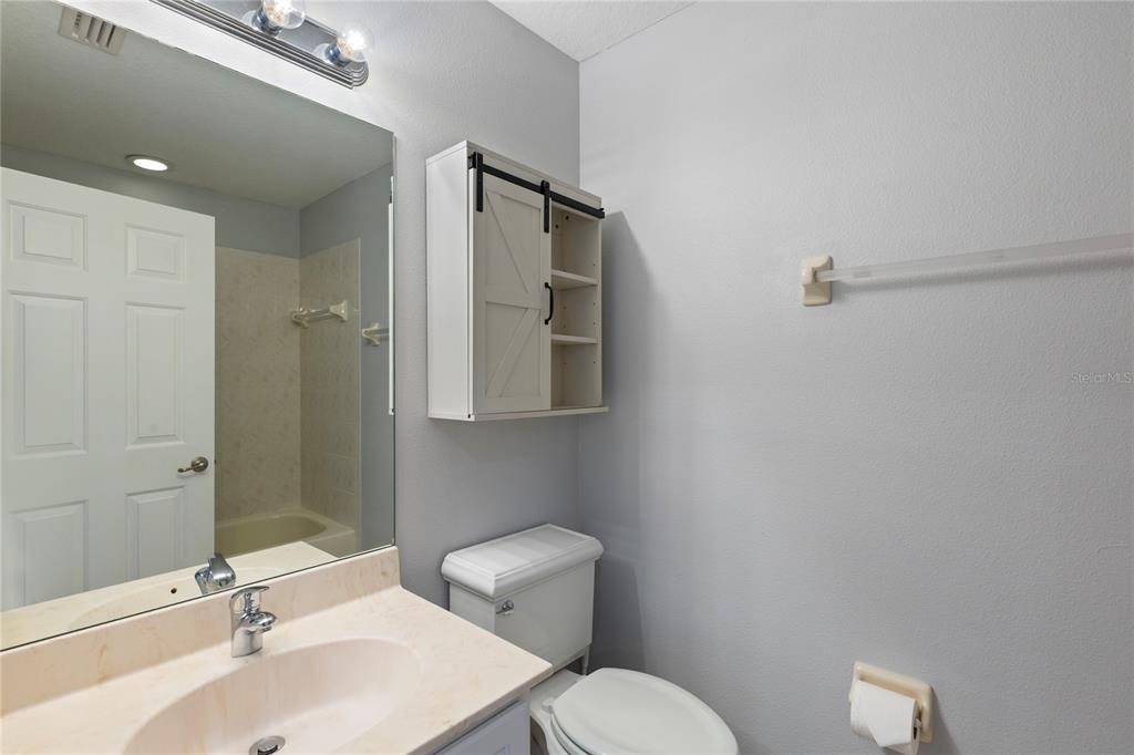 1455 Hidden Court Tarpon Springs, FL 34689 - Photo 21 of 30 a bathroom with a toilet a sink a mirror and vanity