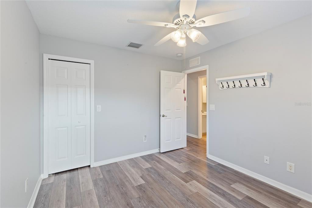 1455 Hidden Court Tarpon Springs, FL 34689 - Photo 25 of 30 an empty room with wooden floor and fan
