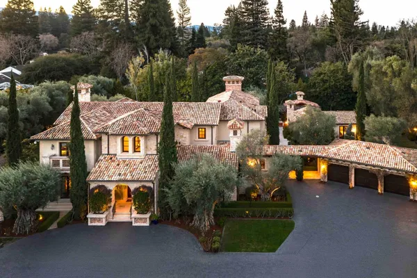 an aerial view of a house with a garden and large trees