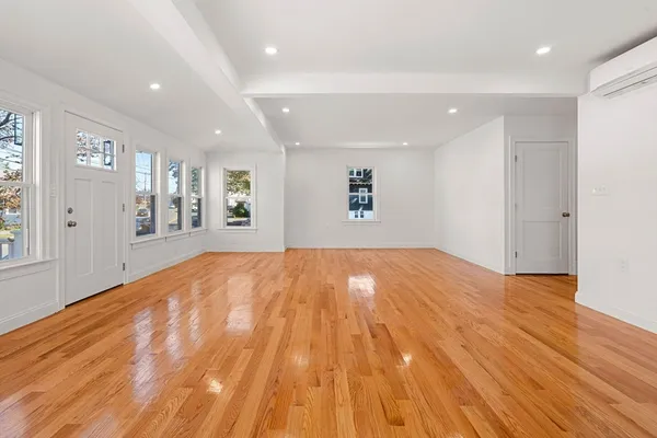 a big room with wooden floor and windows
