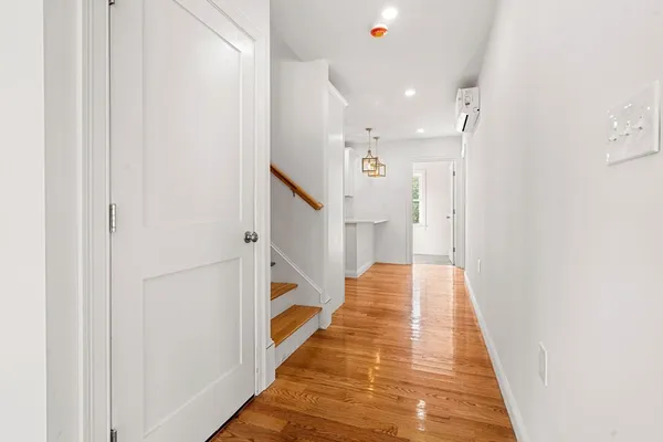 a view of a hallway with wooden floor and staircase