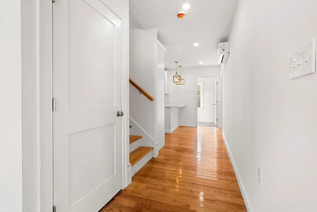 a view of a hallway with wooden floor and staircase