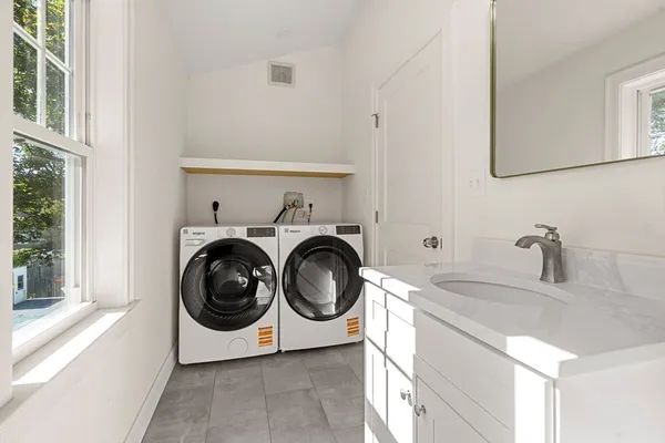 a utility room with sink dryer and washer