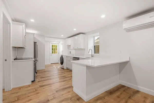 a kitchen with white cabinets and white appliances