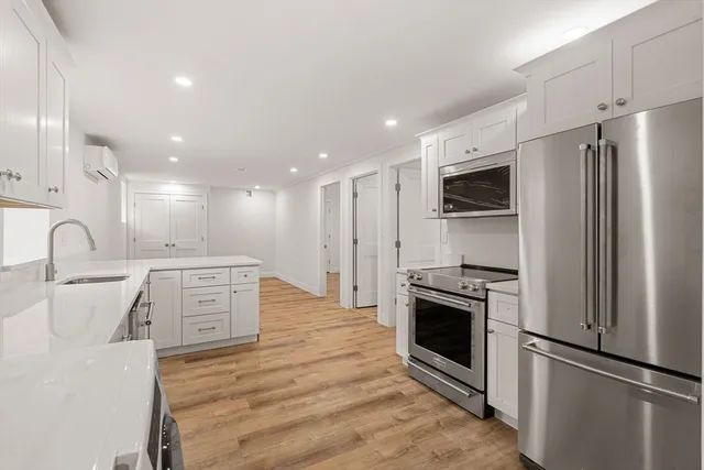 a view of kitchen with stainless steel appliances refrigerator stove microwave and cabinets