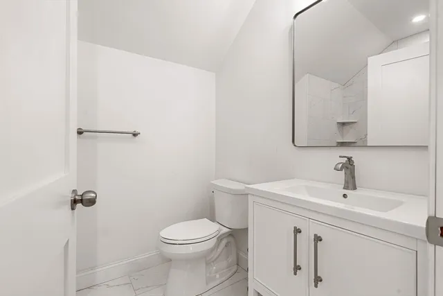 a bathroom with a sink a toilet and a mirror