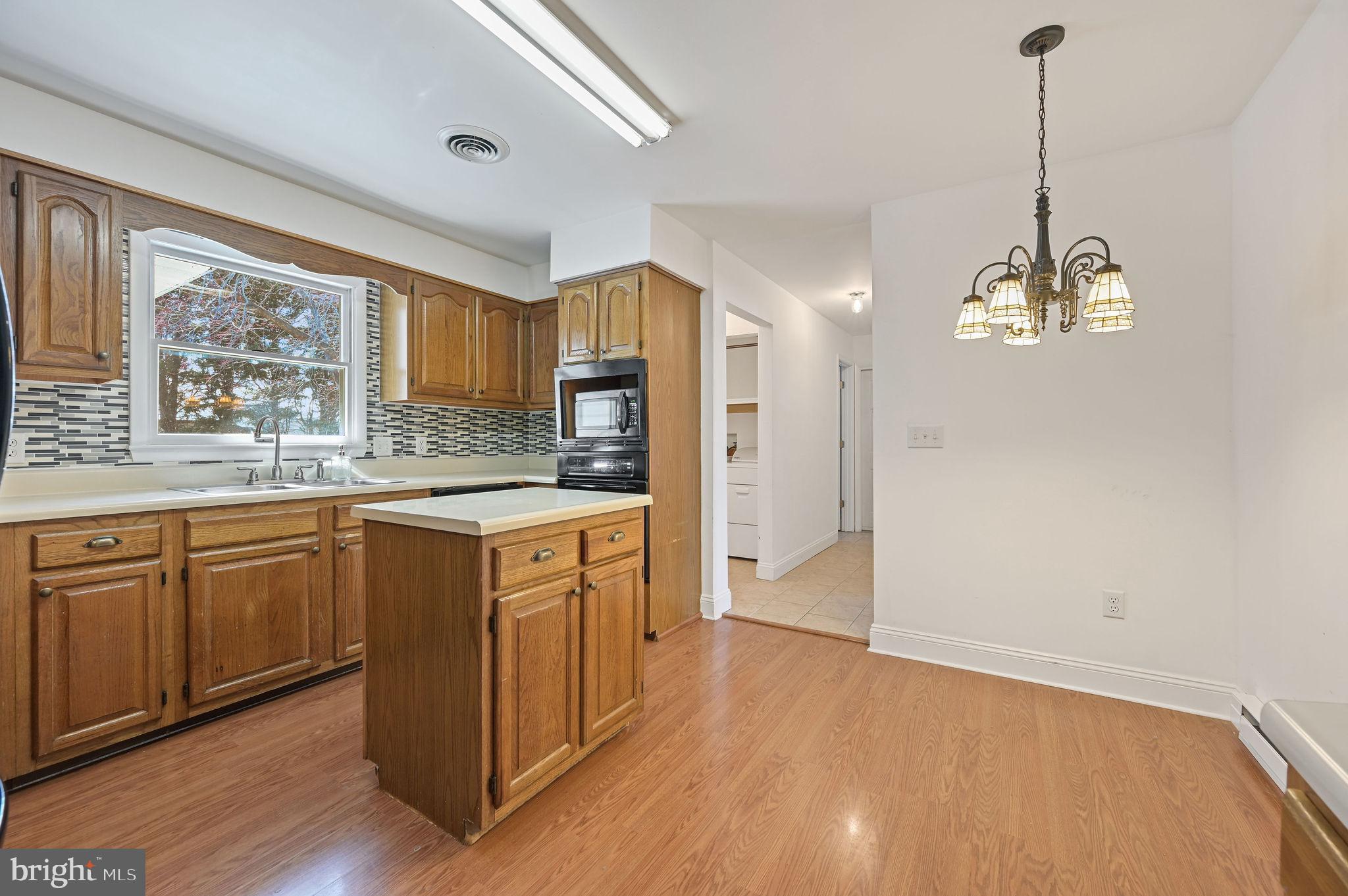 231 East Evens Road Viola, DE 19979 - Photo 14 of 36 a kitchen with granite countertop wooden floors and white cabinets