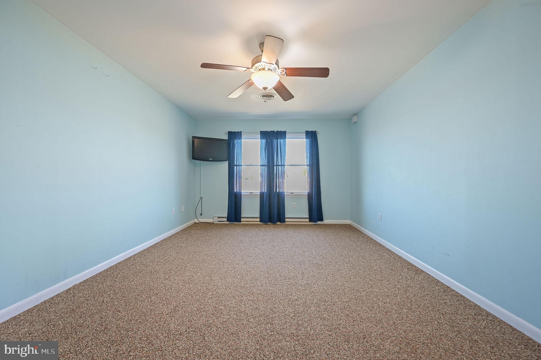 231 East Evens Road Viola, DE 19979 - Photo 25 of 36 an empty room with windows and chandelier fan