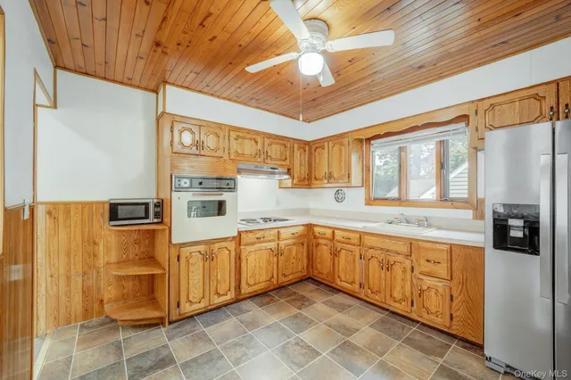 a view of a kitchen with stainless steel appliances granite countertop a refrigerator and cabinets