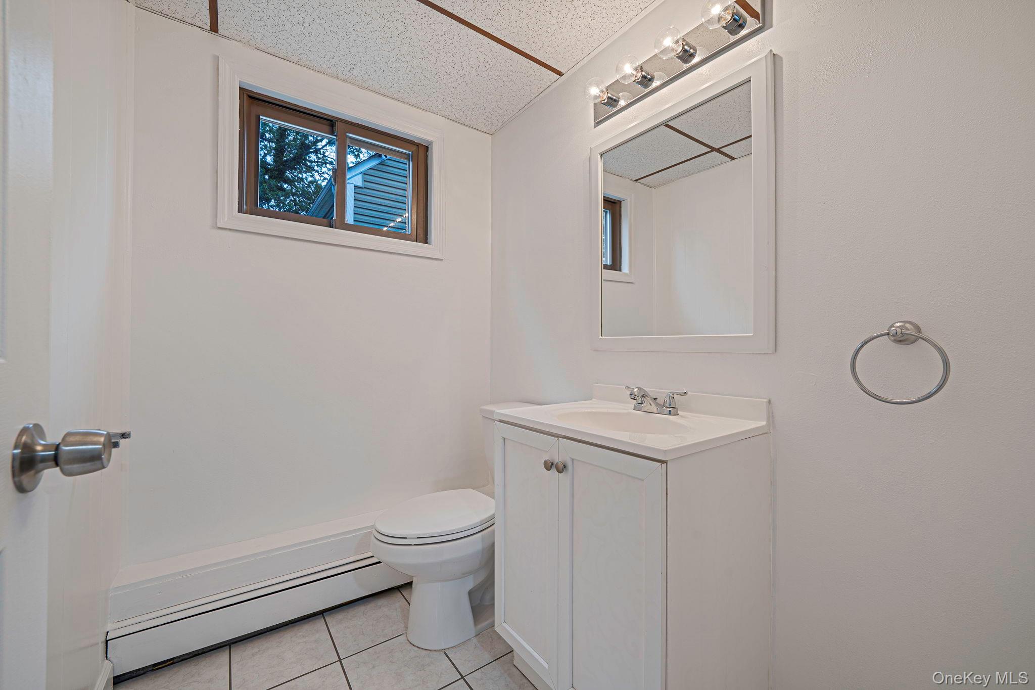 813 Windmill Avenue West Babylon, NY 11704 - Photo 21 of 32 a bathroom with a toilet sink and mirror