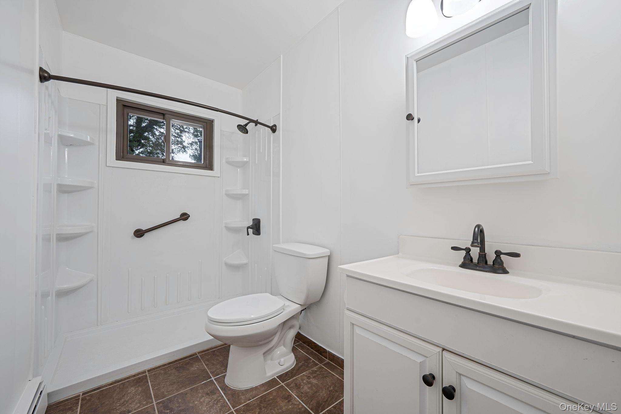 813 Windmill Avenue West Babylon, NY 11704 - Photo 10 of 32 a bathroom with a toilet a sink and a mirror
