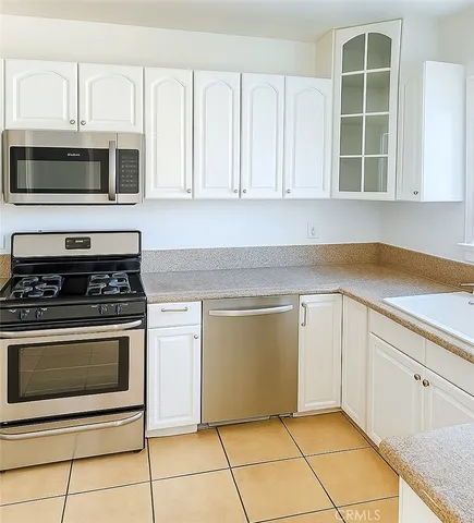 a kitchen with white cabinets appliances and a sink