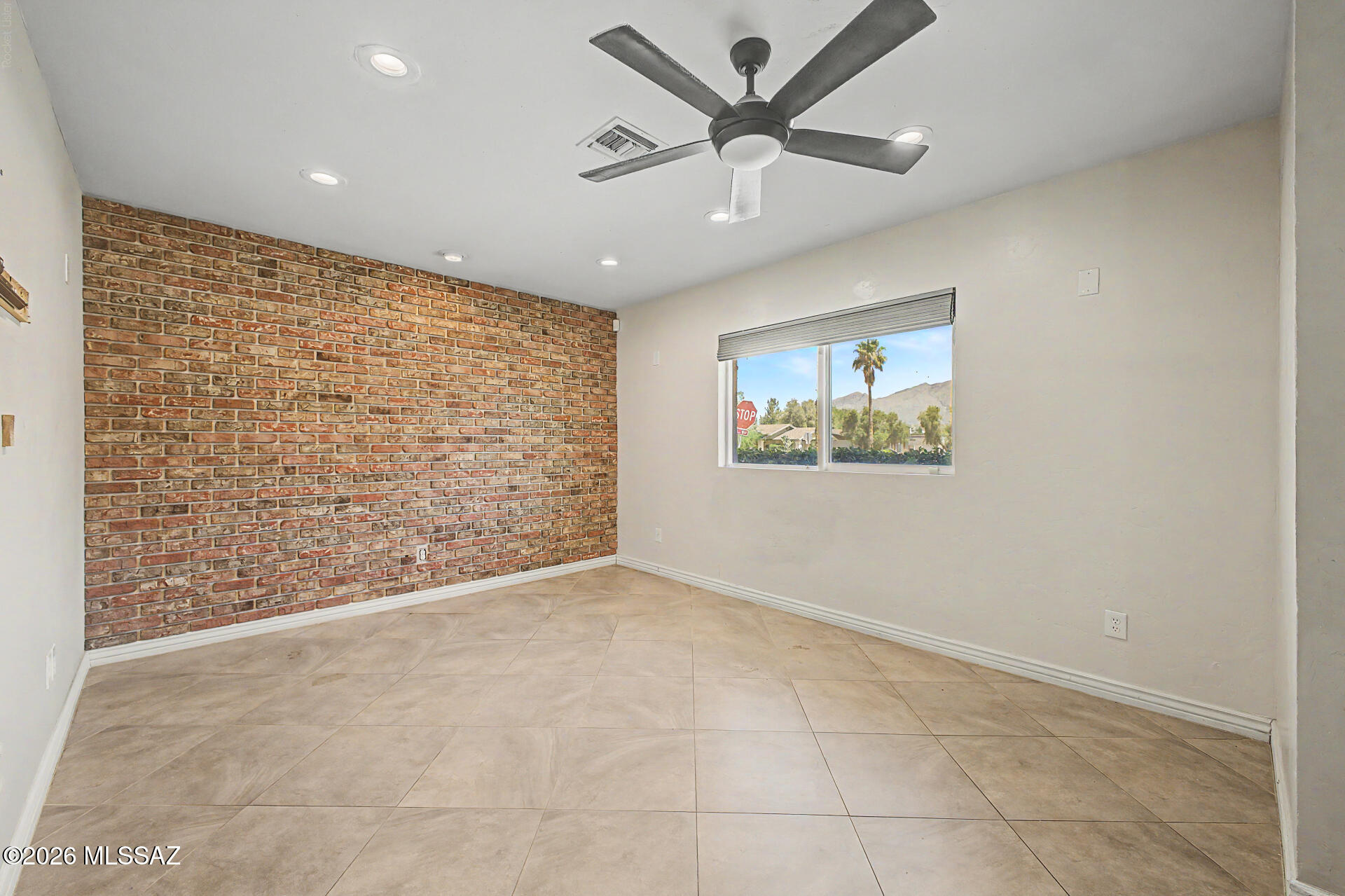 7550 East Rio Verde Drive Tucson, AZ 85715 - Photo 8 of 25 Sunlight pours through the windows, highlighting the inviting brick feature wall & comfortable living area.