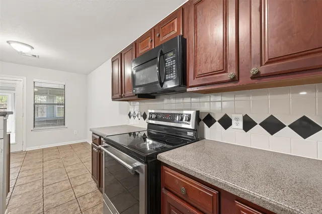 a kitchen with stainless steel appliances granite countertop a sink stove and microwave